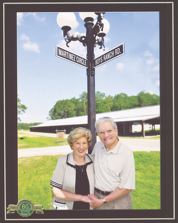 Katie and Danny Martinez stand in front of a street sign named in their honor at Rodeheaver Boys Ranch.